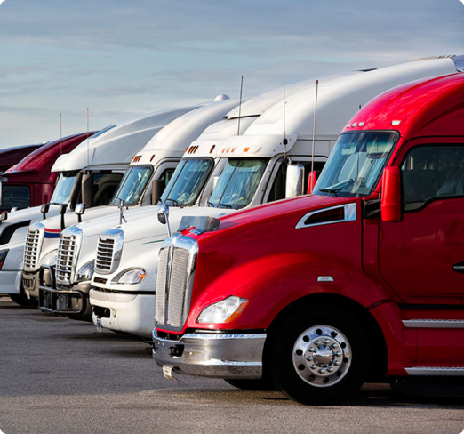 A row of semi trucks parked in a parking lot