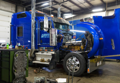 A large blue truck parked inside of a garage