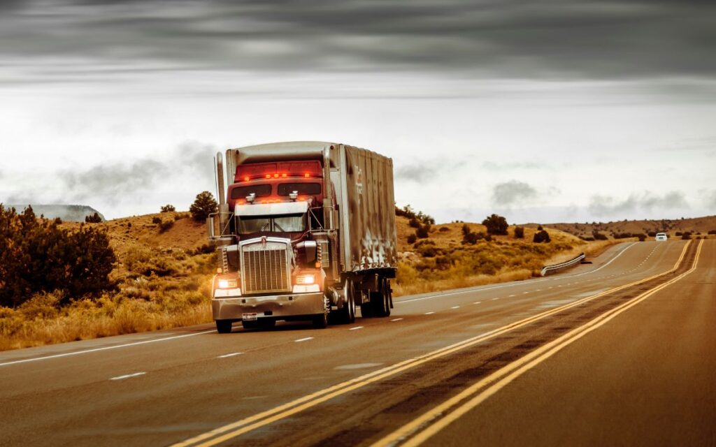 A large diesel semi truck driving down a highway